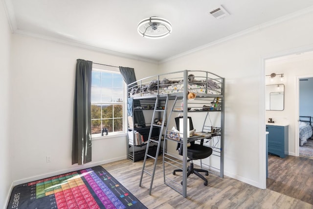 bedroom featuring baseboards, wood finished floors, visible vents, and ornamental molding