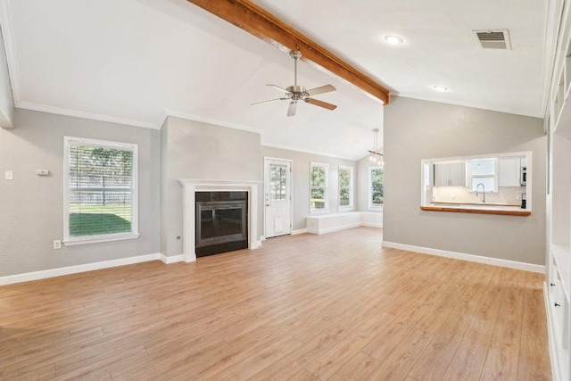 unfurnished living room featuring light wood-type flooring, ornamental molding, a ceiling fan, baseboards, and vaulted ceiling with beams