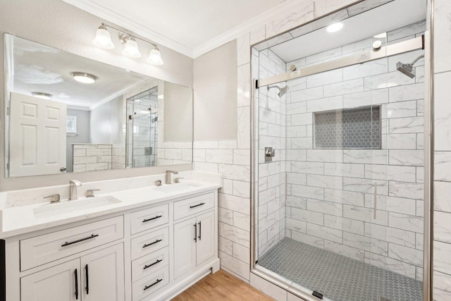 bathroom with crown molding, wood finished floors, a stall shower, and a sink