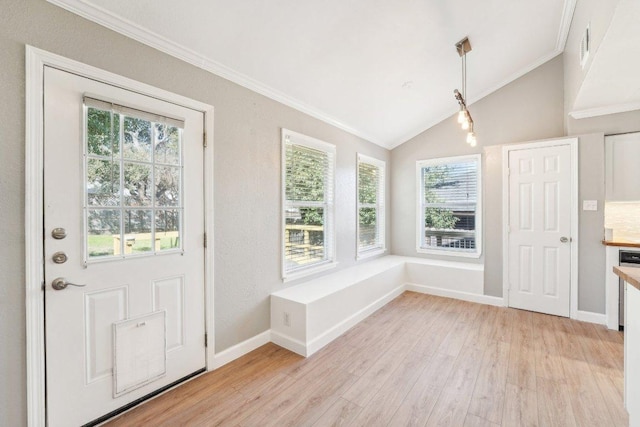 entrance foyer featuring lofted ceiling, light wood-style floors, baseboards, and ornamental molding