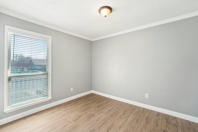 unfurnished room featuring crown molding, wood finished floors, and baseboards