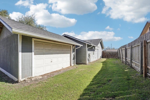 view of property exterior with a garage, a lawn, and fence private yard