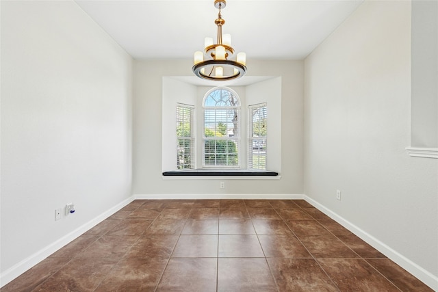 tiled empty room featuring an inviting chandelier and baseboards