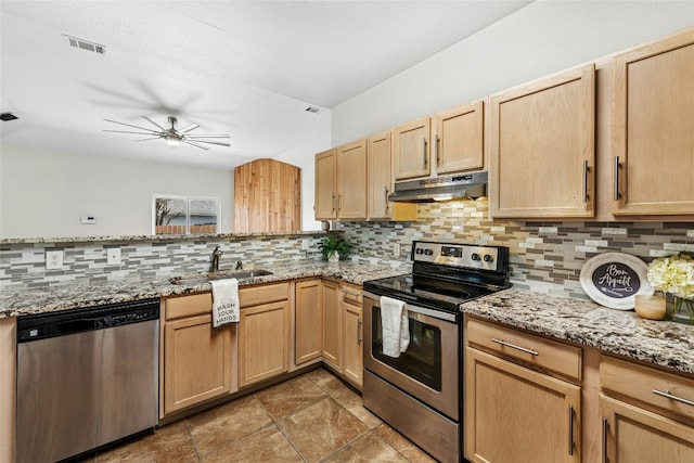 kitchen with visible vents, a sink, under cabinet range hood, appliances with stainless steel finishes, and tasteful backsplash