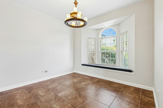 spare room featuring tile patterned flooring, a notable chandelier, and baseboards