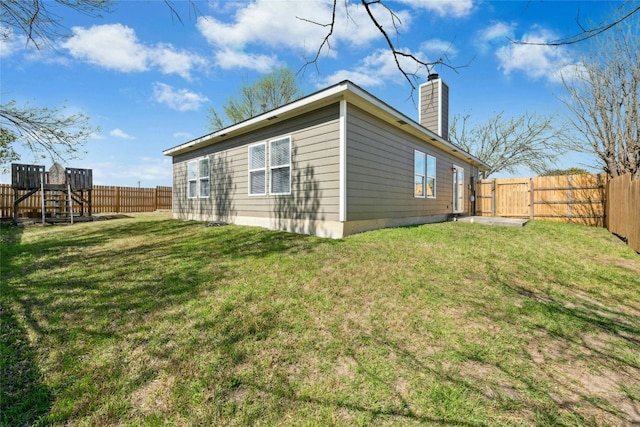 view of property exterior with a fenced backyard, a chimney, and a yard