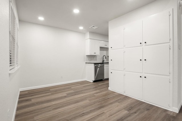 interior space featuring visible vents, baseboards, light wood-type flooring, recessed lighting, and a sink