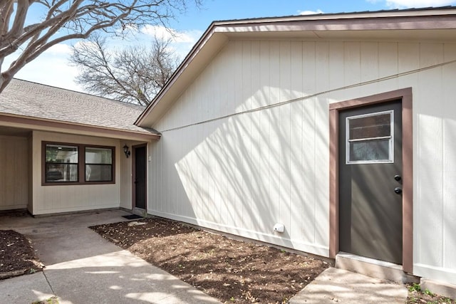 property entrance featuring a shingled roof