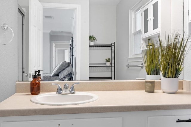 bathroom featuring visible vents, vanity, and crown molding