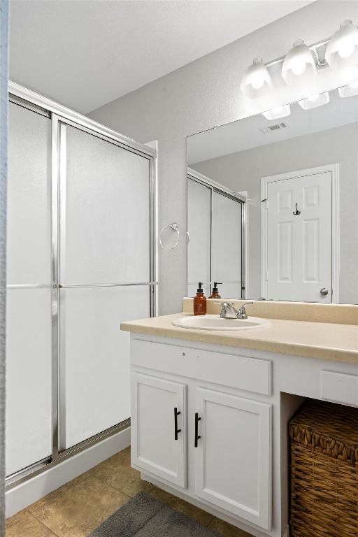 bathroom with tile patterned floors, a shower stall, and vanity