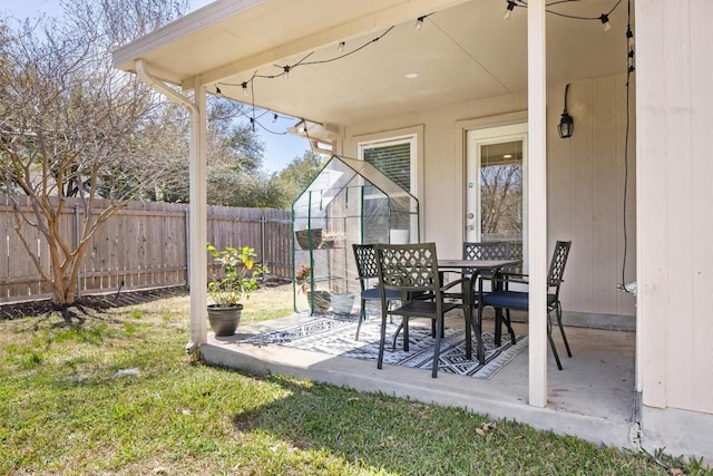 view of patio featuring outdoor dining area and fence