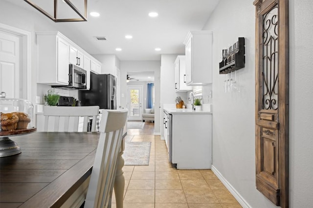 kitchen featuring white cabinetry, recessed lighting, stainless steel appliances, light countertops, and light tile patterned floors