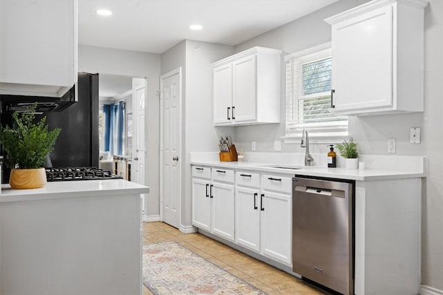 kitchen featuring light tile patterned floors, a sink, light countertops, white cabinets, and stainless steel dishwasher