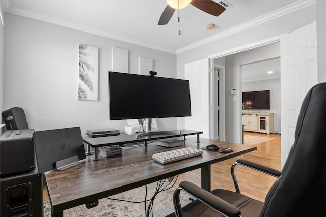 office featuring light wood-style flooring, a ceiling fan, and ornamental molding