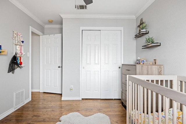 bedroom with crown molding, wood finished floors, and visible vents