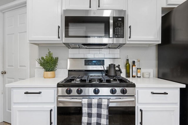 kitchen featuring backsplash, appliances with stainless steel finishes, white cabinetry, and light countertops