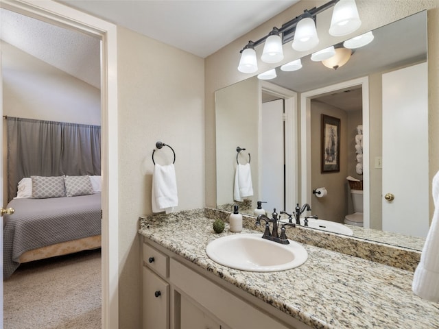 bathroom featuring vanity, toilet, and connected bathroom