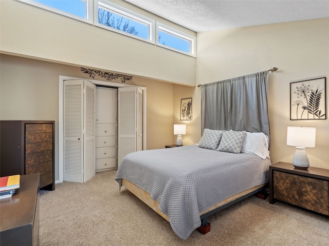 carpeted bedroom featuring a closet, a high ceiling, and a textured ceiling