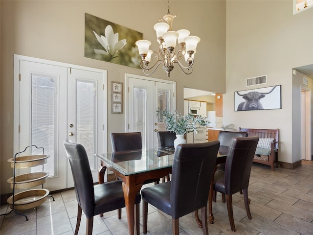 dining space with visible vents, french doors, a high ceiling, an inviting chandelier, and baseboards