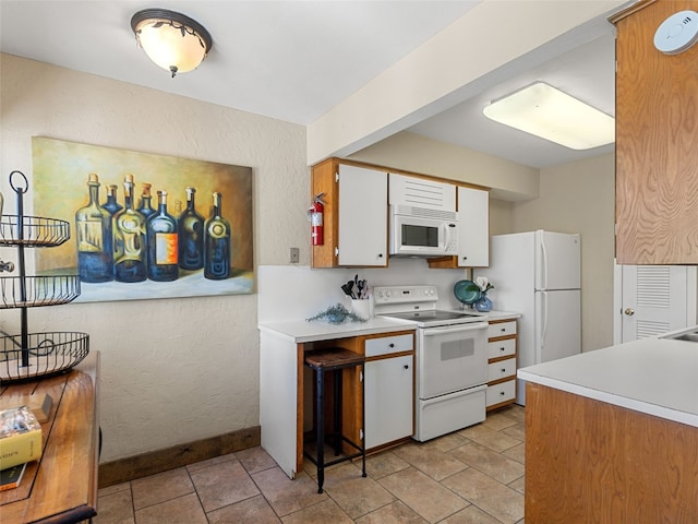 kitchen with white appliances, light countertops, and a textured wall