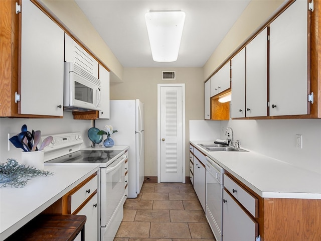 kitchen with white appliances, light countertops, visible vents, and a sink