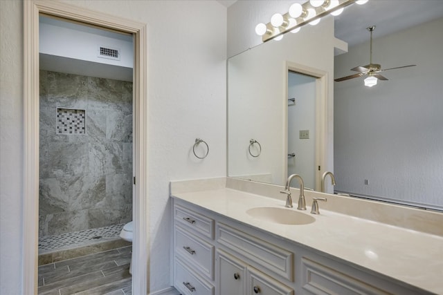 405 S Cowal Dr, Spicewood, TX 78669 - bathroom with toilet, vanity, tiled shower, and ceiling fan