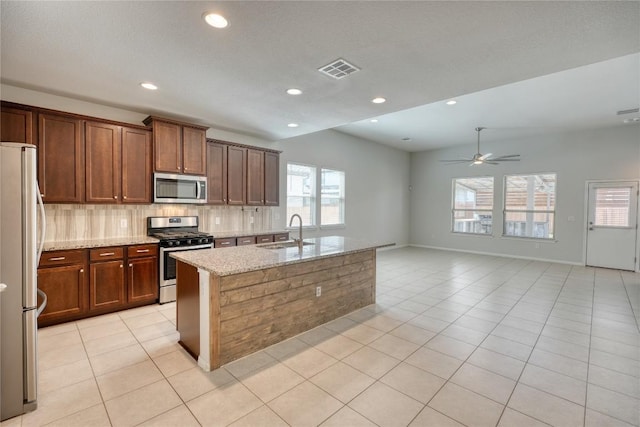 183 Concho Creek Loop, Leander, TX 78641 - kitchen with appliances with stainless steel finishes, a ceiling fan, light tile patterned floors, light stone counters, and recessed lighting