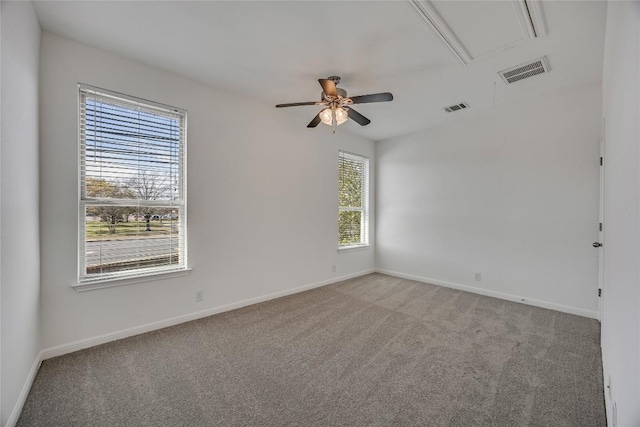 spare room featuring visible vents, light carpet, attic access, and ceiling fan