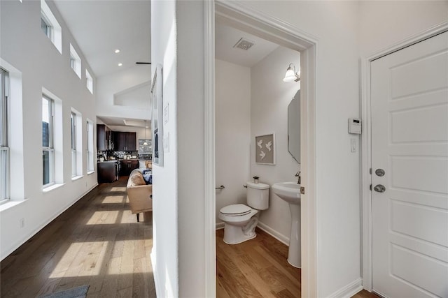 bathroom with visible vents, plenty of natural light, toilet, and wood finished floors