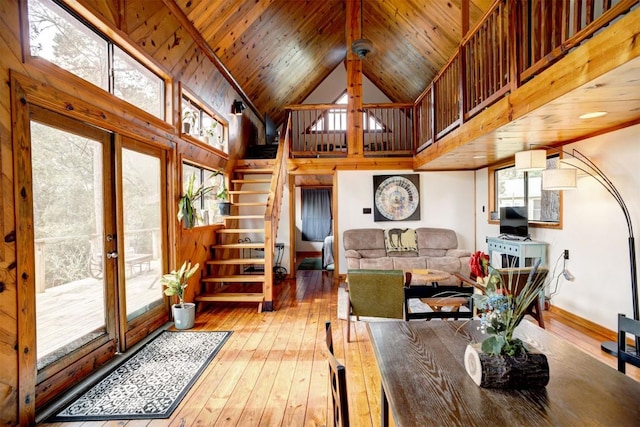 dining space featuring baseboards, high vaulted ceiling, stairs, wood-type flooring, and wooden ceiling