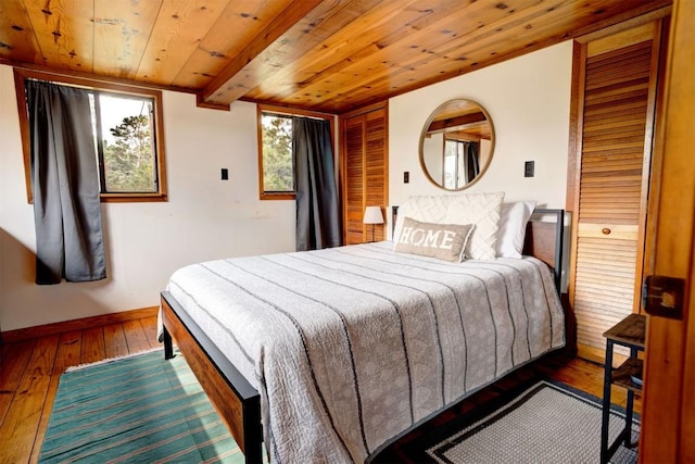 bedroom featuring wooden ceiling, hardwood / wood-style flooring, and baseboards