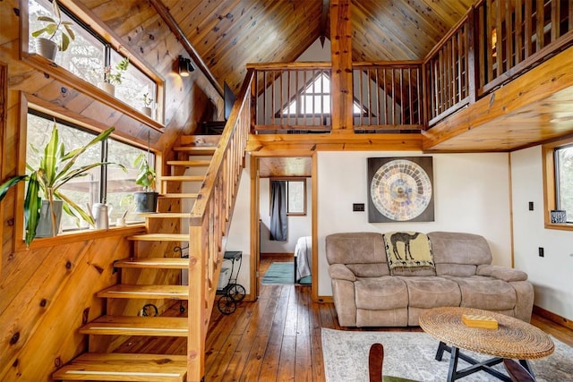 living area with a high ceiling, wood ceiling, stairs, and hardwood / wood-style flooring