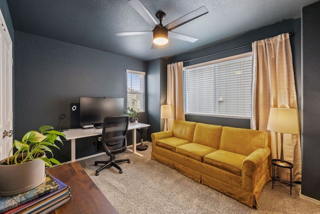 office space with carpet, a ceiling fan, and a textured ceiling