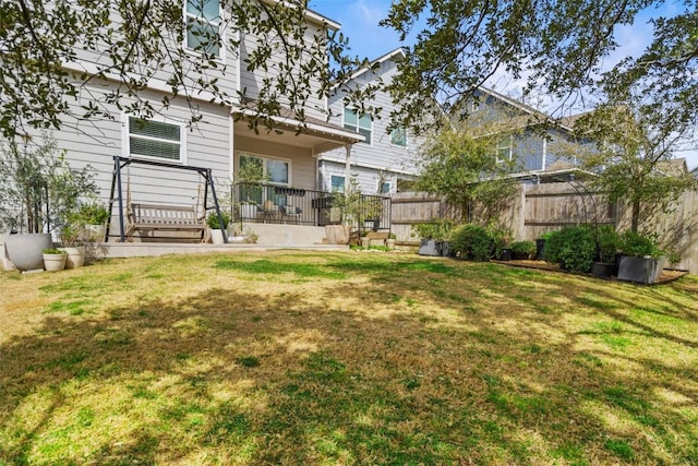 rear view of property with a yard and fence