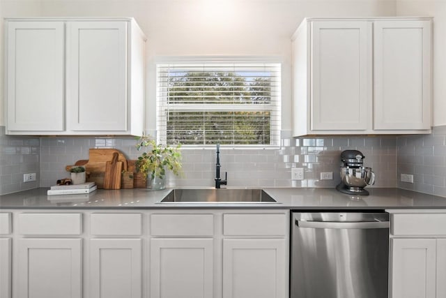 kitchen with a sink, stainless steel dishwasher, and white cabinets