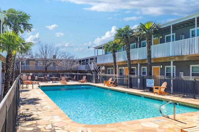 community pool featuring a patio and fence