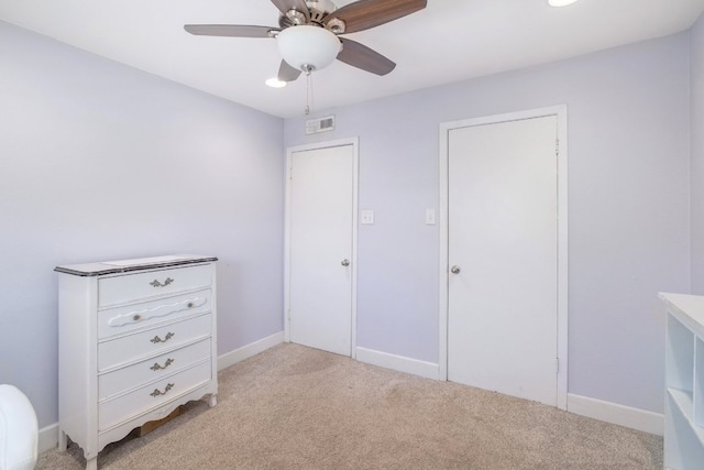 unfurnished bedroom with visible vents, light colored carpet, a ceiling fan, and baseboards