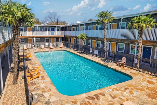 community pool featuring a patio and fence