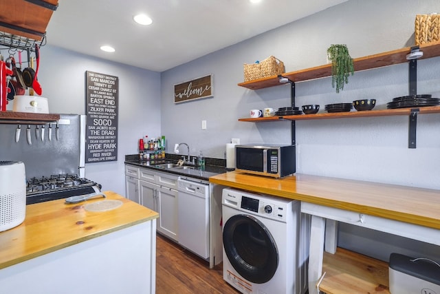 kitchen featuring open shelves, washer / clothes dryer, white dishwasher, a sink, and stainless steel microwave