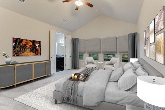 carpeted bedroom with visible vents, lofted ceiling, ensuite bath, and a ceiling fan