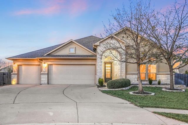 view of front of house featuring a garage, stone siding, driveway, and stucco siding