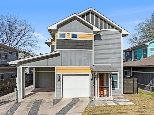 view of front facade featuring fence, board and batten siding, concrete driveway, an attached garage, and a carport