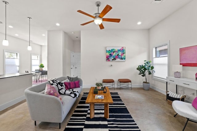 living room featuring a ceiling fan, visible vents, baseboards, concrete floors, and recessed lighting