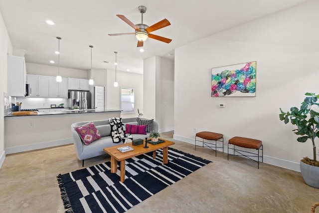 living room featuring recessed lighting, baseboards, finished concrete floors, and a ceiling fan