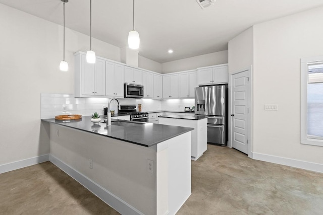 kitchen featuring a sink, appliances with stainless steel finishes, a peninsula, baseboards, and concrete flooring