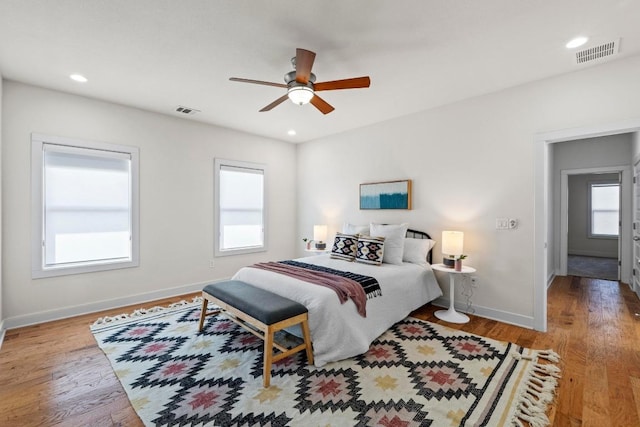 bedroom with recessed lighting, wood finished floors, visible vents, and baseboards