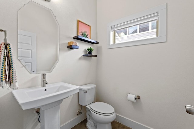 bathroom with toilet and baseboards