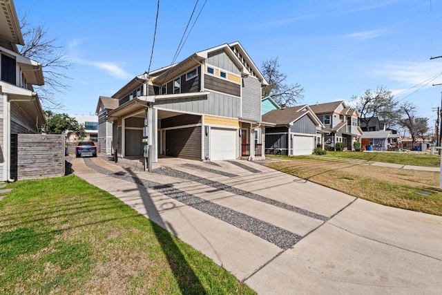 view of front of home featuring driveway, a front lawn, a garage, board and batten siding, and a residential view