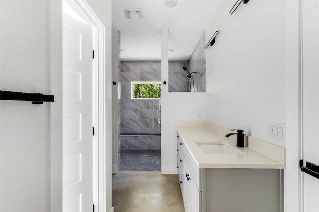 bathroom featuring vanity, tiled shower, and finished concrete floors