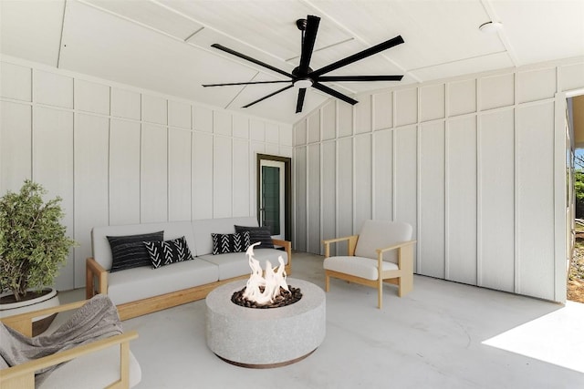 living area featuring concrete floors, ceiling fan, and vaulted ceiling
